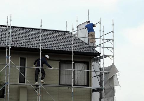 足場から外壁を塗装する作業風景のイメージ